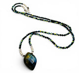 Necklace with a large labradorite pendant on a white background