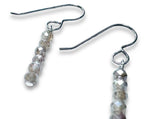 Pair of silver earrings with moonstone gemstone beads on a white background