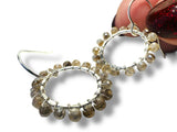 Close-up of beaded hoop earrings on a white background