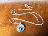 Silver necklace with a pendant on a brown surface