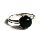 Silver ring with a black gemstone on a white background