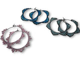 Three pairs of hoop earrings in different colors on a white background