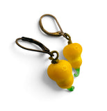 A pair of dangling earrings with yellow pear-shaped charms and green stem details, attached to antique bronze leverback hooks, shown on a white background.