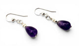 Purple teardrop earrings with silver hooks on a white background