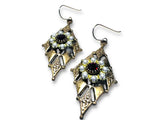 Pair of ornate earrings with gemstones on a white background