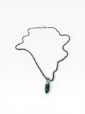Necklace with a green crystal pendant on a white background