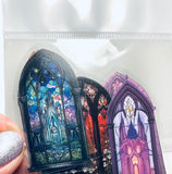 Three colorful stained glass window stickers in a clear plastic bag.